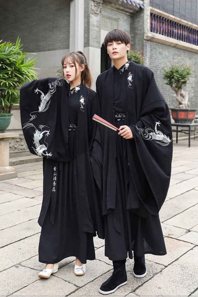 Han Dynasty couple in traditional swordsman costumes, featuring black hanfu and intricate dragon designs.