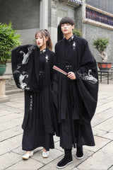 Han Dynasty couple in traditional swordsman costumes, featuring black hanfu and intricate dragon designs.
