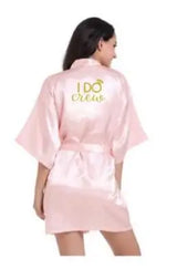 Light pink satin bridesmaid robe with 'I Do Crew' text, perfect for elegant wedding preparations.