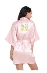 Light pink satin bridesmaid robe with 'Sister of the Bride' text, ideal for elegant wedding celebrations.