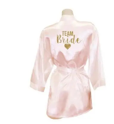 Elegant light pink satin bridesmaid robe with 'TEAM Bride' printed in gold glitter.