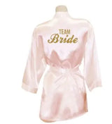 Light pink satin bridesmaid robe with 'TEAM BRIDE' text, perfect for weddings and bridal parties.