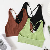 Three seamless crop tops in brown, black, and green with stylish cross-back straps, perfect for women's streetwear.
