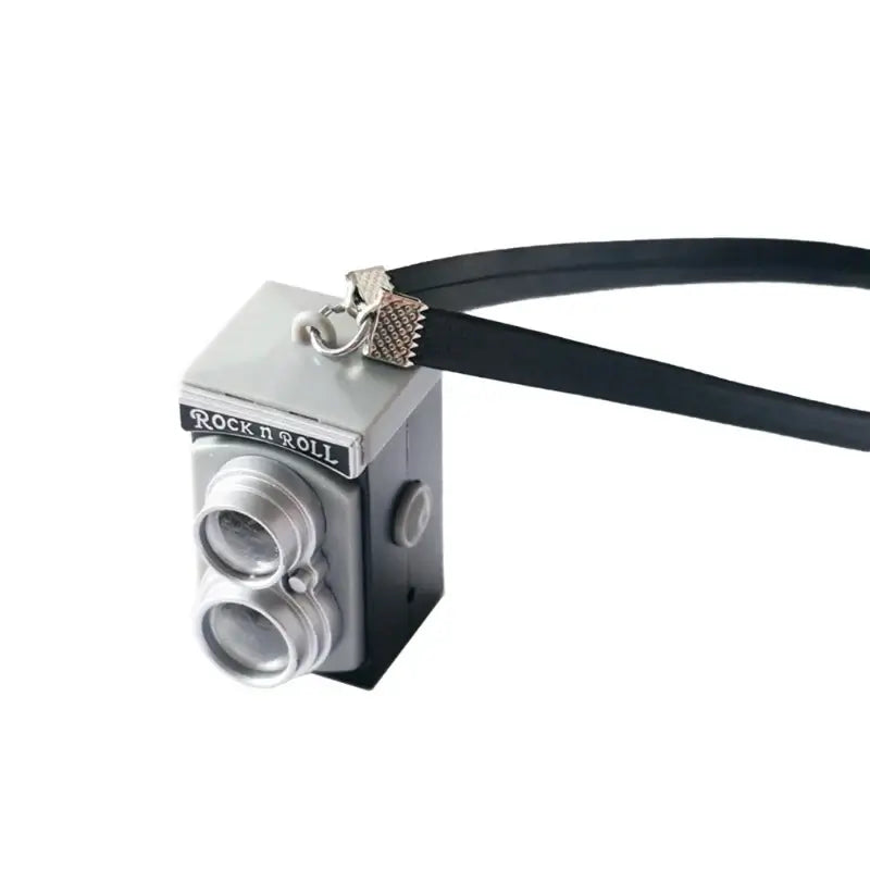 Miniature black camera accessory for dollhouses, perfect for baby photography props and imaginative play.