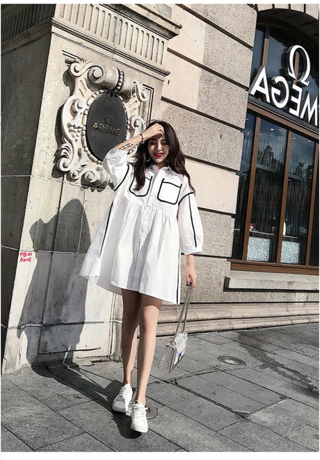 Woman in a white turn-down collar shirt dress with pockets, ideal for summer outings and stylish beach parties.