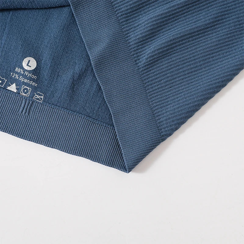 Close-up of MonoSculpt™ one-shoulder seamless crop top revealing fabric composition and care instructions.