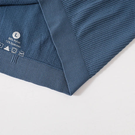 Close-up of MonoSculpt™ one-shoulder seamless crop top revealing fabric composition and care instructions.