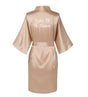Back view of a satin rose gold bridesmaid robe with 'Sister Of The Groom' text in elegant font.