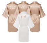 Rose gold satin robes with titles for Mother of the Bride, Maid of Honor, and Bridesmaid, alongside a white Bride robe.