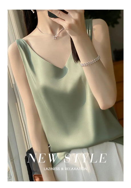 Model wearing a green satin v-neck camisole top, showcasing a stylish summer look with elegance.