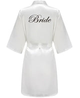 Elegant white satin robe for brides, featuring 'Bride' in stylish black lettering on the back.