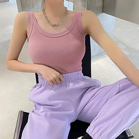 Model wearing a pink ribbed tank top paired with lavender joggers, showcasing a casual streetwear style.