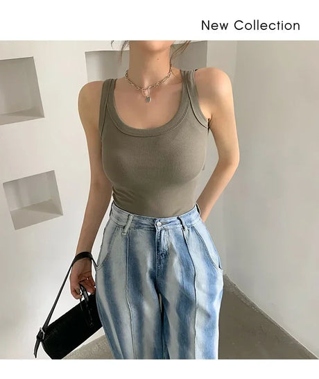 Model wearing a sleeveless olive green RetroRib™ tank top paired with light blue high-waisted jeans.