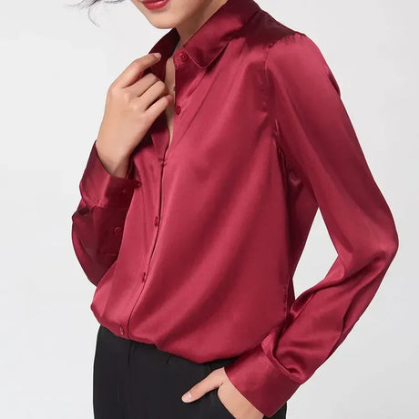 Woman wearing a satin long sleeve silk shirt in burgundy, featuring a v-neck and single-breasted closure.
