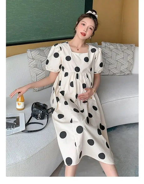 Casual polka dot loose maternity dress in cream, perfect for summer, showcasing a relaxed fit and mid-calf length.