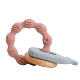 Soft silicone baby teether rings in pink and blue, safe for infants to relieve gum pain.
