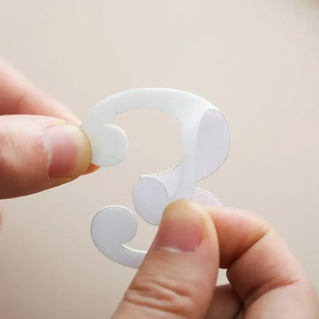 Person holding a white number three milestone card for baby photography.