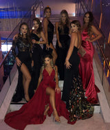 Group of women in elegant evening dresses, showcasing diverse styles, colors, and designs at a formal event.