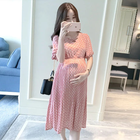 Chiffon polka dot maternity dress in summer pink, featuring short sleeves and pleated silhouette, perfect for casual wear.