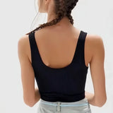 Back view of a woman wearing a black seamless ribbed camisole tank top.