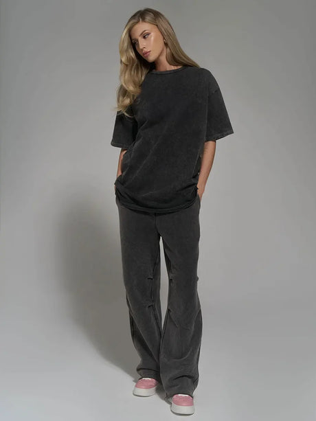 Model showcasing a relaxed-fit gray outfit, featuring a loose top and wide-leg pants, ideal for casual wear.