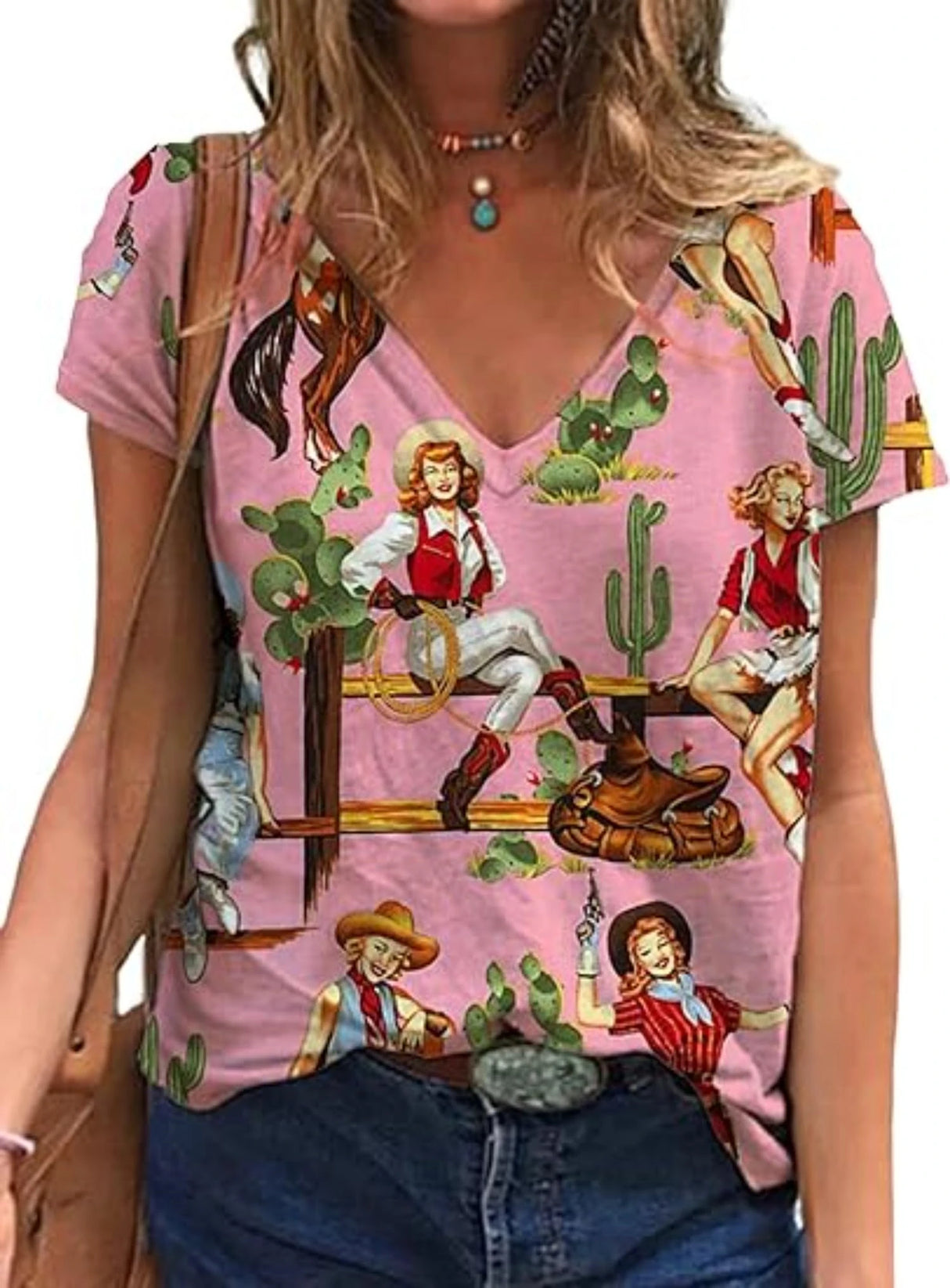 Western cowgirl graphic t-shirt featuring floral and cowboy motifs on a pink background, ideal for casual wear.
