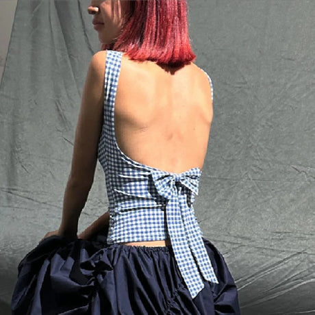 Back view of a woman wearing a plaid bow backless crop top, showcasing its stylish design and trendy streetwear vibe.