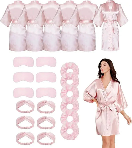 Bulk set of short silky satin bride robes in pink with matching eye masks and scrunchies for wedding parties.