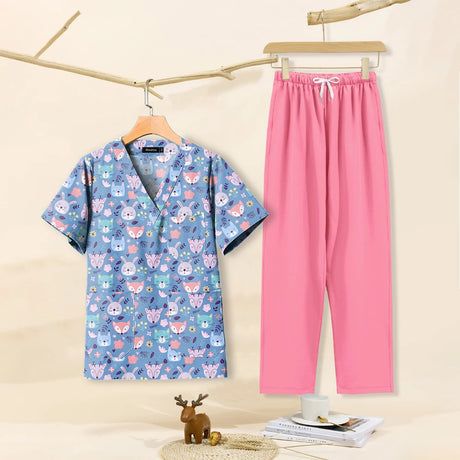 Cartoon print dental scrubs set in blue and pink, featuring v-neck top and matching pants for pet grooming professionals.