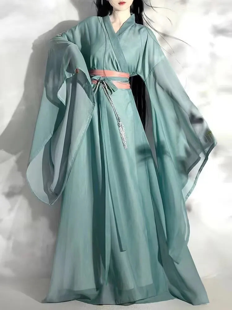 Elegant woman in a flowing mint green Hanfu dress with billowing sleeves and a pink sash, perfect for cosplay and traditional occasions.