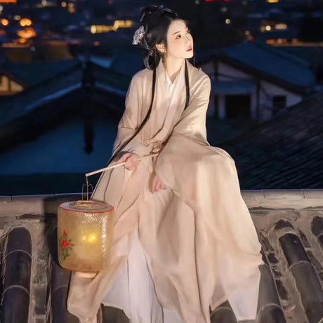 Woman in traditional Hanfu costume sitting on a rooftop at night with a lantern, showcasing Tang Dynasty style.