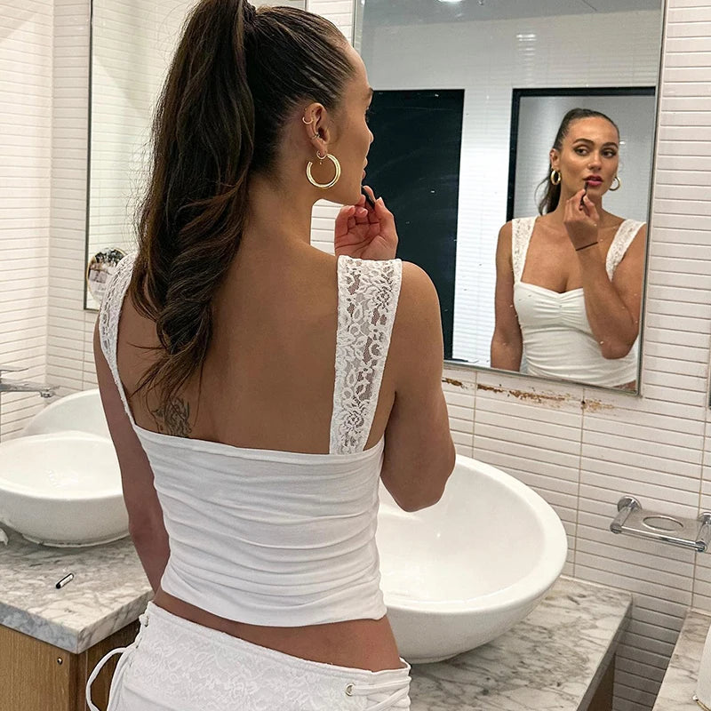 Woman wearing a lace strap pleated camisole tank top in a bathroom mirror reflection.