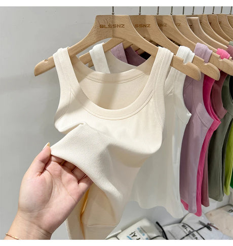 RibFlex™ Basic O-Neck Tank in cream color hanging with other vibrant options in a store display.