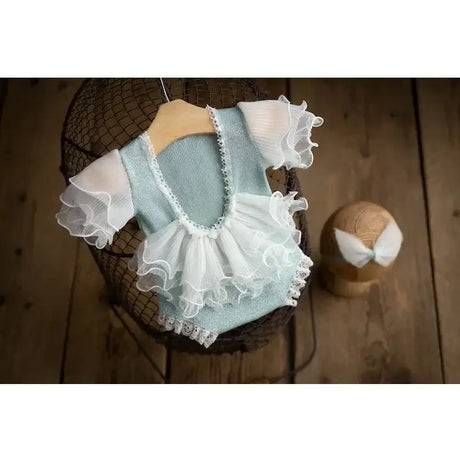 Newborn photography prop featuring a mint green outfit with ruffled sleeves and a matching headband, ideal for baby photos.