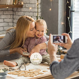 Mom and baby celebrating 12 months with milestone card, capturing memories during a baking session.
