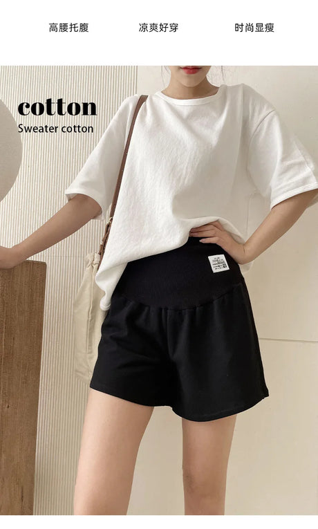 Female model wearing black adjustable maternity shorts styled with a casual white cotton t-shirt.