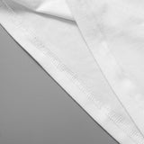 Close-up of the hem and stitch detailing on a white knitted camisole tank top.