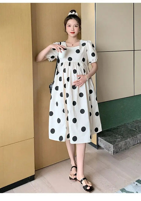 Polka dot loose maternity dress in white and black, perfect for summer, featuring a mid-calf length and short sleeves.