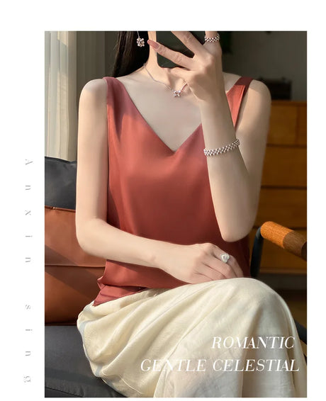 Woman wearing a sleeveless v-neck top in rust color, sitting in a stylish home setting.