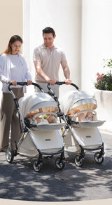 Couple walking with twins in stylish white twin baby stroller, showcasing durability and convenience for parents.