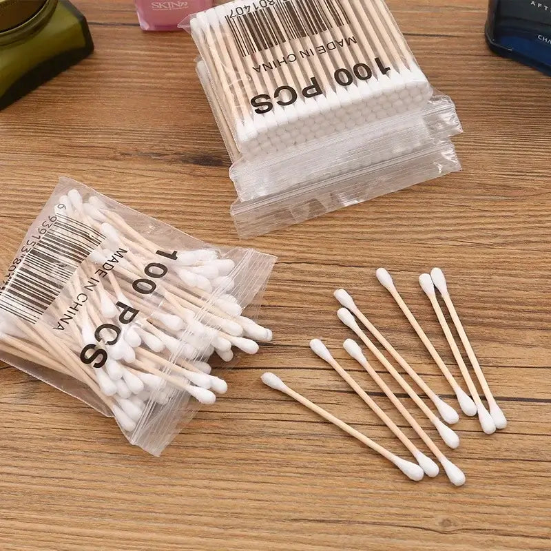 100pcs bag of baby cotton swabs on wooden surface, ideal for infants and toddlers, made from wood and cotton.