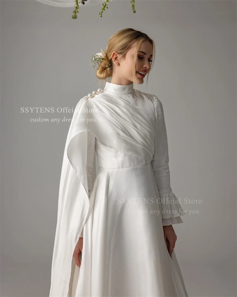 Elegant Muslim satin wedding dress with high neck and long sleeves, embellished with pearls and draped details.