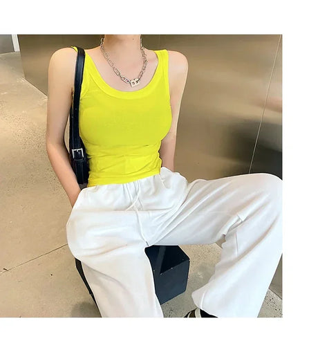 Model wearing bright yellow RetroRib™ 90s vintage ribbed tank top with white pants in a modern setting.