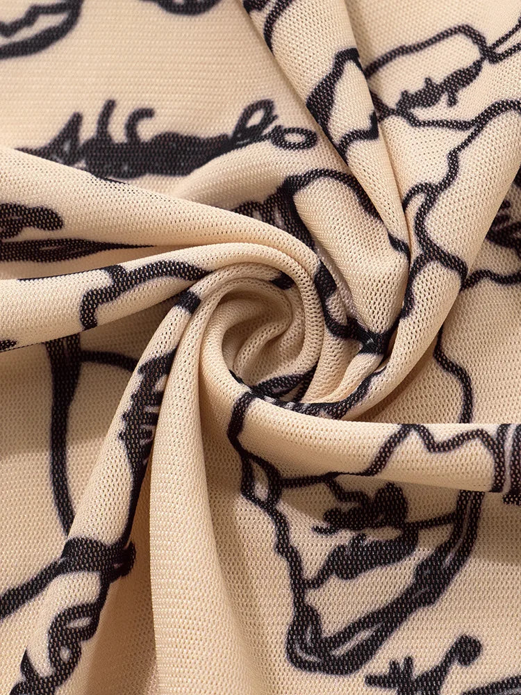 Close-up of lightweight printed fabric with a swirl pattern in beige and black, showcasing the texture and design.
