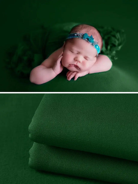 Newborn sleeping on a green soft wrap blanket with a headband, perfect for photography accessories.