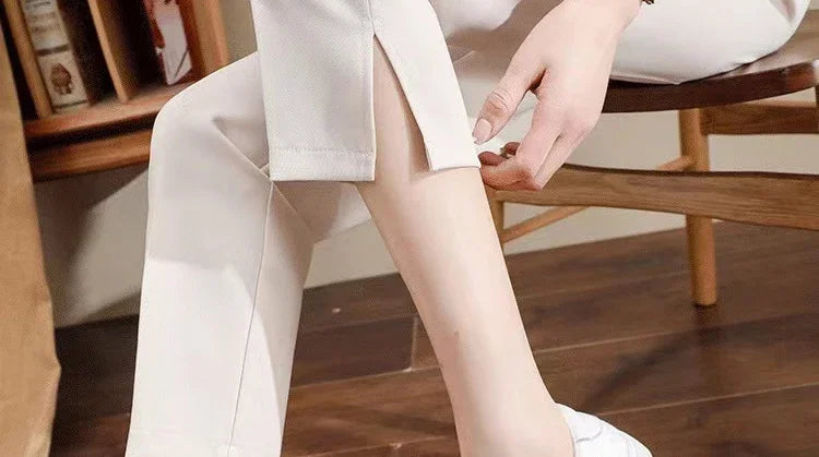 Close-up of a woman's leg in formal black maternity pants, showcasing a stylish slit detail, ideal for summer work wear.