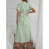 Back view of a woman wearing a striped short sleeve maternity dress in green with a tie waist, perfect for casual summerwear.