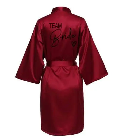 Team Bride satin robe in burgundy with elegant lettering on back, perfect for bridal parties.