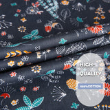 Close-up of high-quality 100% cotton fabric with colorful floral patterns on a dark background.