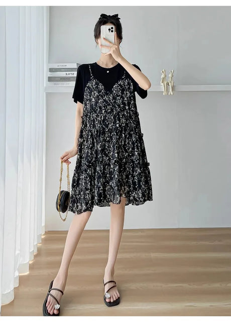 Woman wearing a stylish black floral dress, perfect for summer occasions or casual outings.